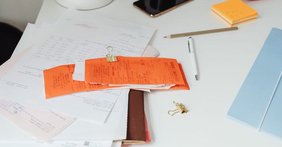 Receipts and a notebook spread across a desk