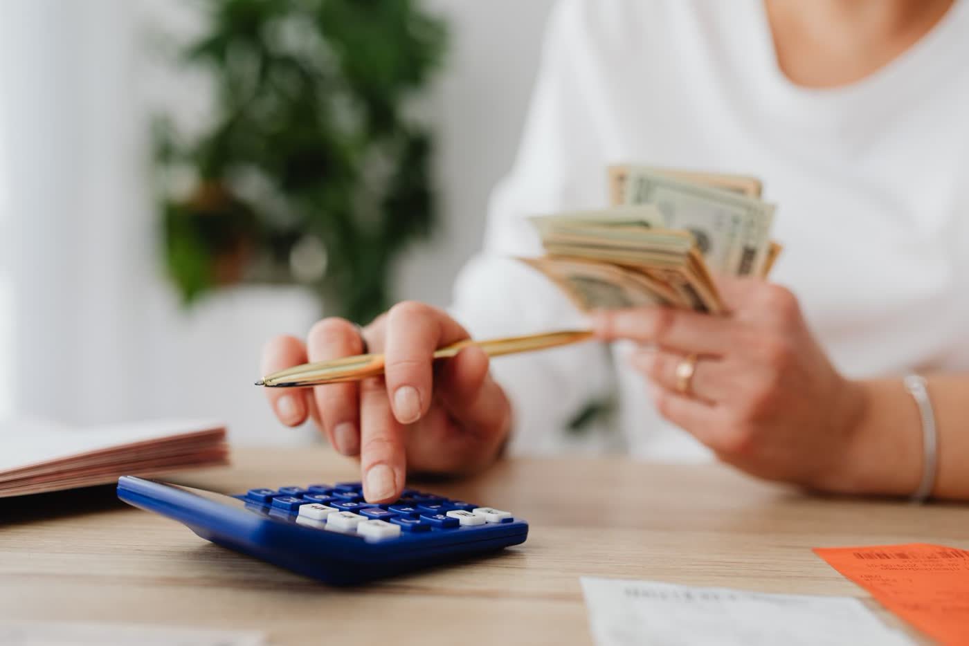 Person using a calculator to plan a monthly budget